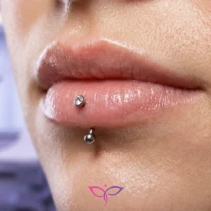 انجام تخصصی پیرسینگ لب (مدل ورتیکال لبرت) در کلینیک پرنیان مشهد با آنژیوکت و نگین ضد حساسیت.